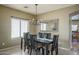 Elegant dining area featuring a modern chandelier and a large window for natural light at 11832 W Electra Ln, Sun City, AZ 85373
