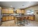 Spacious kitchen featuring an island with seating, stainless steel appliances, and wood cabinetry at 11832 W Electra Ln, Sun City, AZ 85373