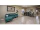 Comfortable living room with a green sofa, decorative wall art, and tile flooring at 11832 W Electra Ln, Sun City, AZ 85373