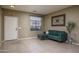 Cozy living room featuring tile flooring, ample natural light, and a comfortable green sofa at 11832 W Electra Ln, Sun City, AZ 85373