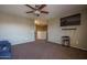 An additional living area, featuring a plush sofa, a ceiling fan, and a TV for cozy entertainment at 11832 W Electra Ln, Sun City, AZ 85373