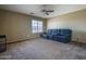 Spacious living room with plush carpet, a ceiling fan, and a comfortable sofa, perfect for relaxing at 11832 W Electra Ln, Sun City, AZ 85373