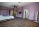 Expansive primary bedroom boasts a four-poster bed, large windows, ceiling fan, and ensuite bathroom access at 11832 W Electra Ln, Sun City, AZ 85373