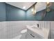 Stylish powder room featuring white tiling, blue accent wall, and modern fixtures and lighting at 12222 N 74Th St, Scottsdale, AZ 85260