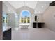 Bright bathroom featuring a soaking tub, glass shower, double vanity, and a large arched window at 12222 N 74Th St, Scottsdale, AZ 85260