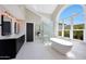 Bright bathroom boasting a soaking tub, glass shower, double vanity, and a large arched window at 12222 N 74Th St, Scottsdale, AZ 85260