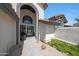 Home entryway features a tall arched door, tiled walkway, and colorful flowers at 12222 N 74Th St, Scottsdale, AZ 85260