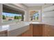 Bright kitchen with a farmhouse sink, modern appliances, and a view of the pool area for a charming culinary experience at 12222 N 74Th St, Scottsdale, AZ 85260