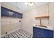 Bright laundry room featuring star-patterned floors, and blue cabinetry at 12222 N 74Th St, Scottsdale, AZ 85260