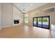 Bright living room with a stone fireplace and floor-to-ceiling sliding glass doors leading to the pool at 12222 N 74Th St, Scottsdale, AZ 85260