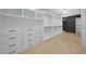 Walk-in closet with custom shelving, drawers, wood-look floors, and modern lighting at 12222 N 74Th St, Scottsdale, AZ 85260