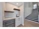 Stylish wet bar featuring wood shelves, a beverage refrigerator, and a sink, complemented by stairs in the background at 12222 N 74Th St, Scottsdale, AZ 85260
