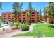 Beautiful condo complex exterior featuring lush landscaping and a community pool with a waterfall feature at 12222 N Paradise Village S Pkwy # 220, Phoenix, AZ 85032