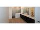 Modern bathroom featuring dual vanities, black cabinetry, and a marble-walled shower at 12324 W Parkway Ln, Avondale, AZ 85323