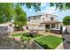 Landscaped backyard with artificial turf, patio table, and a hot tub at 13088 N 91St Dr, Peoria, AZ 85381