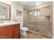 Bathroom featuring tiled shower, wooden vanity, mirror, decorative plant, and a toilet at 15014 N 48Th Pl, Scottsdale, AZ 85254