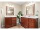 Bathroom featuring dual wooden vanities with mirrors, light fixtures, tile flooring, and a decorative plant at 15014 N 48Th Pl, Scottsdale, AZ 85254