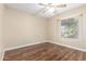Empty bedroom with wood floors, neutral paint, window with blinds, and a ceiling fan at 15014 N 48Th Pl, Scottsdale, AZ 85254