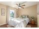 Cozy bedroom featuring a ceiling fan, decorative pillows, window with curtains, and a stylish side table at 15014 N 48Th Pl, Scottsdale, AZ 85254
