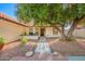 Inviting front entrance featuring a covered porch and a large shade tree in a low maintenance desert landscape at 15014 N 48Th Pl, Scottsdale, AZ 85254