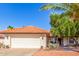 Charming single-story home with a two-car garage, desert landscaping, and a beautiful, arched, tile roof at 15014 N 48Th Pl, Scottsdale, AZ 85254