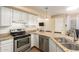 Kitchen featuring white cabinets, granite countertops, stainless steel appliances and a view of the living room at 15014 N 48Th Pl, Scottsdale, AZ 85254
