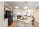 Open kitchen with granite counters, stainless steel appliances, white cabinets and view to the living room at 15014 N 48Th Pl, Scottsdale, AZ 85254