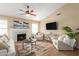 Open-concept living room featuring wood floors, a fireplace, and neutral decor at 15014 N 48Th Pl, Scottsdale, AZ 85254