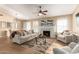 Bright living room with fireplace, wood floors, ceiling fan, and natural light from multiple windows at 15014 N 48Th Pl, Scottsdale, AZ 85254