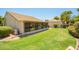 Back yard showing green grass and the exterior of an enclosed Arizona room at 160 Leisure World -- # 160, Mesa, AZ 85206