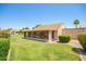 Backyard with a view of enclosed Arizona room and view of neighborhood landscaping at 160 Leisure World -- # 160, Mesa, AZ 85206
