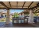 A well-equipped outdoor kitchen with a built-in grill, cabinets, and stone accents under a covered patio at 160 Leisure World -- # 160, Mesa, AZ 85206
