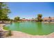A scenic view of a lush pond with a fountain, surrounded by well-maintained landscaping and charming community homes at 160 Leisure World -- # 160, Mesa, AZ 85206