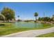 Scenic community pond with fountain, lush trees and landscaping, offering a serene environment for residents at 160 Leisure World -- # 160, Mesa, AZ 85206