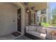 Inviting front porch with seating, stone accents, decorative lantern, and wood shutters at 1713 E Bridgeport Pkwy, Gilbert, AZ 85295