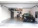 Spacious garage with storage shelves and a sleek black electric car parked inside at 1713 E Bridgeport Pkwy, Gilbert, AZ 85295
