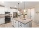 Modern kitchen island with pendant lighting, stainless steel appliances, and white cabinets at 1713 E Bridgeport Pkwy, Gilbert, AZ 85295