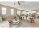 Open concept living room with a large sectional couch, dining table, and white kitchen at 1713 E Bridgeport Pkwy, Gilbert, AZ 85295