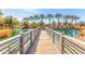 A wooden bridge leads into a serene community pond with a water fountain at 1713 E Bridgeport Pkwy, Gilbert, AZ 85295