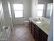 Bright bathroom featuring double sinks with wooden cabinets and a separate shower and tub at 18548 W Sunbelt Dr, Surprise, AZ 85374