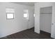 A well-lit bedroom featuring wood-look floors, windows, and closet space at 18548 W Sunbelt Dr, Surprise, AZ 85374