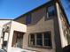 Exterior view of home featuring a covered patio, large windows and textured stucco finish at 18548 W Sunbelt Dr, Surprise, AZ 85374