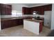 Well-lit kitchen features granite countertops, dark wood cabinets, and stainless steel appliances at 18548 W Sunbelt Dr, Surprise, AZ 85374