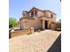Tan stucco two-story home with desert landscaping, tile roof, and charming front entrance at 1902 N 106Th Ave, Avondale, AZ 85392