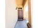 Inviting entryway with brown front door, covered porch, and neutral-toned exterior at 1902 N 106Th Ave, Avondale, AZ 85392