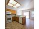 Functional kitchen featuring wooden cabinets, white appliances, and breakfast bar at 1902 N 106Th Ave, Avondale, AZ 85392