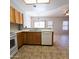 Kitchen featuring wooden cabinets, white appliances, open layout into living space at 1902 N 106Th Ave, Avondale, AZ 85392