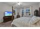 This primary bedroom features a four poster bed, TV, and natural light at 20269 E Hummingbird Dr, Queen Creek, AZ 85142