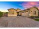 Well-maintained stucco home features a spacious three-car garage and a patterned brick driveway at 20269 E Hummingbird Dr, Queen Creek, AZ 85142