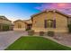 Charming single-story home boasts a landscaped front yard and inviting facade under a vibrant evening sky at 20269 E Hummingbird Dr, Queen Creek, AZ 85142